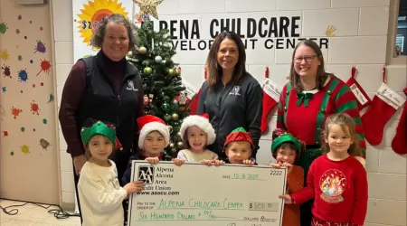 Community Foundation of Northeast Michigan Youth Advisory Council Members pose with a $505.00 check and posters advertising YAC Day